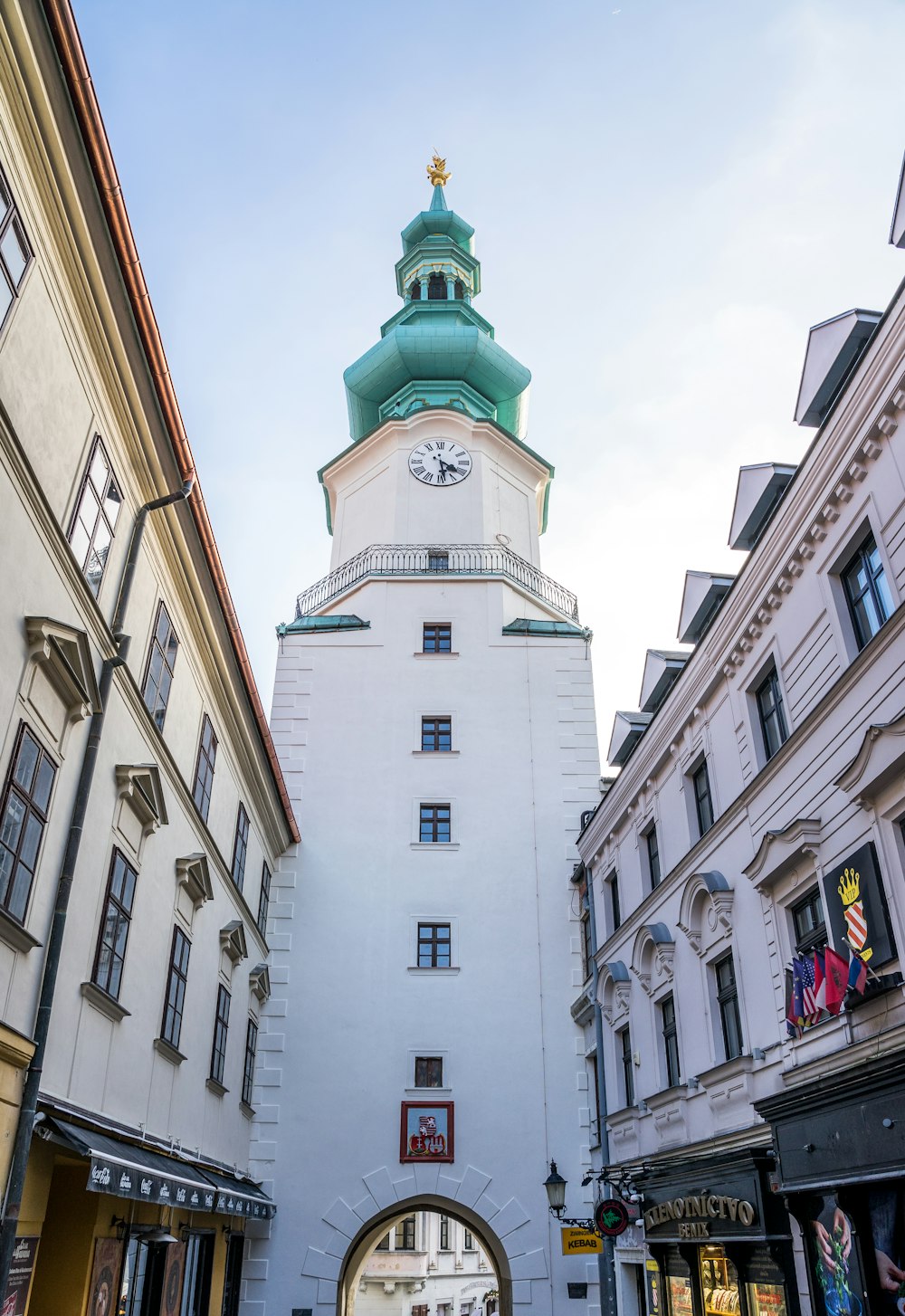 a tall white building with a clock on the top of it