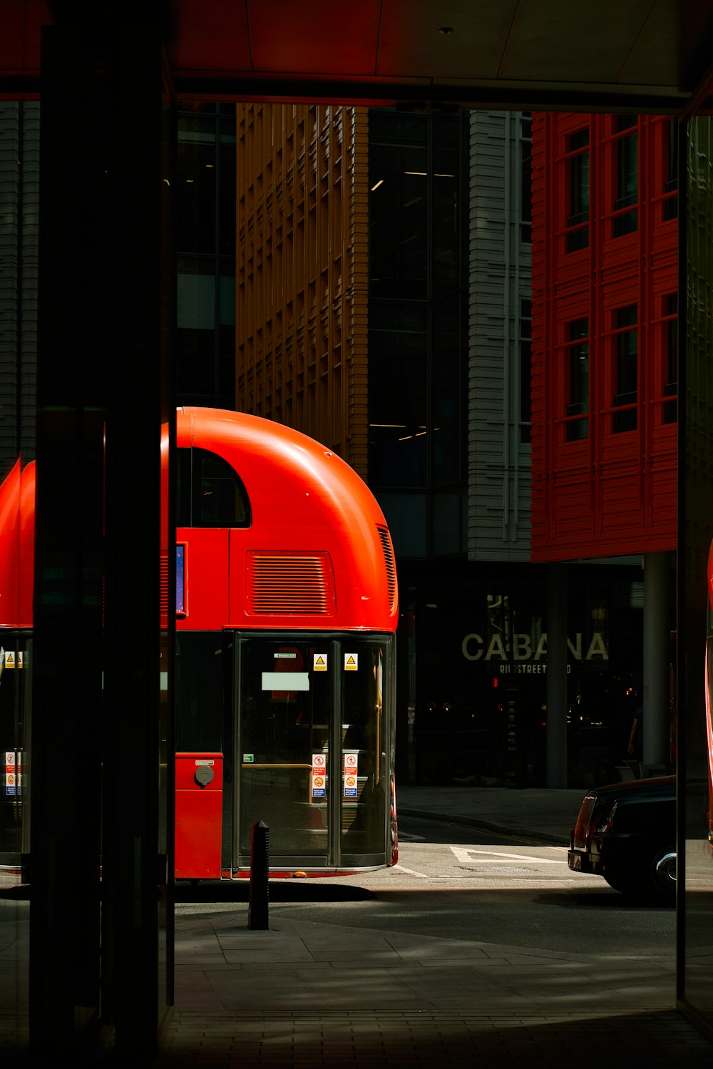 a red double decker bus driving down a street