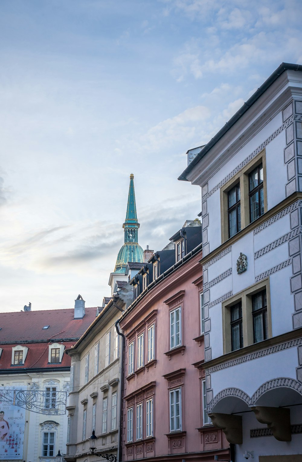 a row of buildings with a steeple in the background