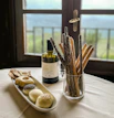 An influencer tasting premium olive oil in a sunlit kitchen with natural decor.