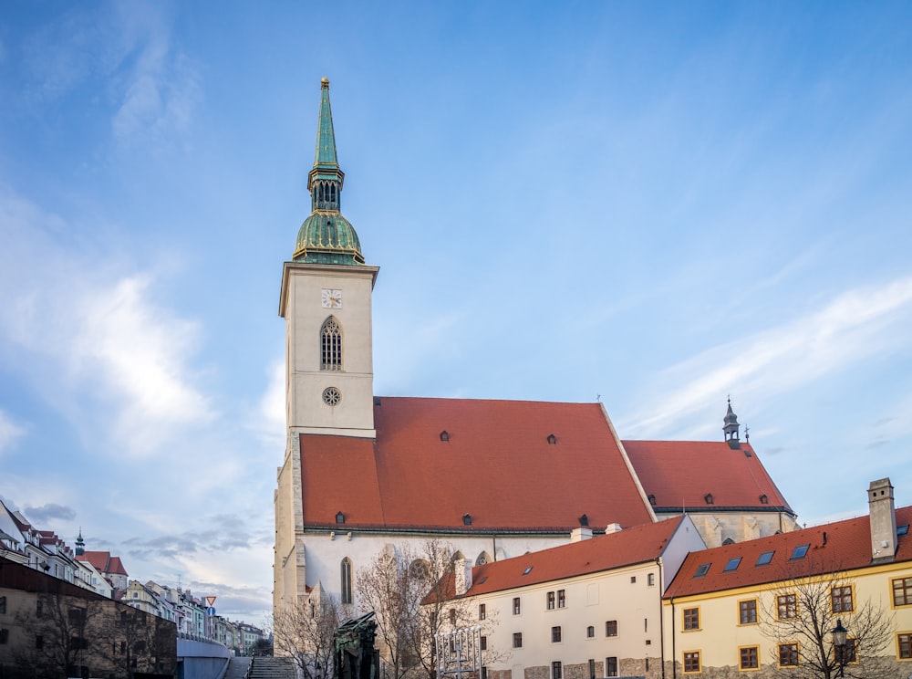 ein hohes weißes Gebäude mit einem grünen Kirchturm