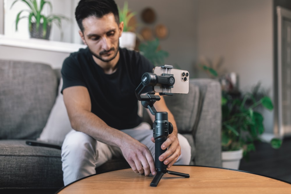 a man sitting on a couch holding a camera