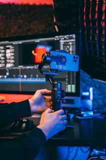 a person holding a camera in front of a computer