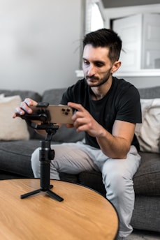 A focused man watching an online course on a tablet in a cozy home setting.