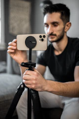 A homeowner adjusting smart doorbell settings on a smartphone in a cozy living room