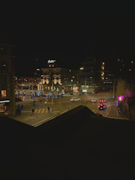 Close-up of a Vigilia road camera capturing a busy intersection with cars and pedestrians under bright streetlights.