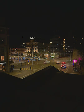 Close-up of a Vigilia road camera capturing a busy intersection with cars and pedestrians under bright streetlights.