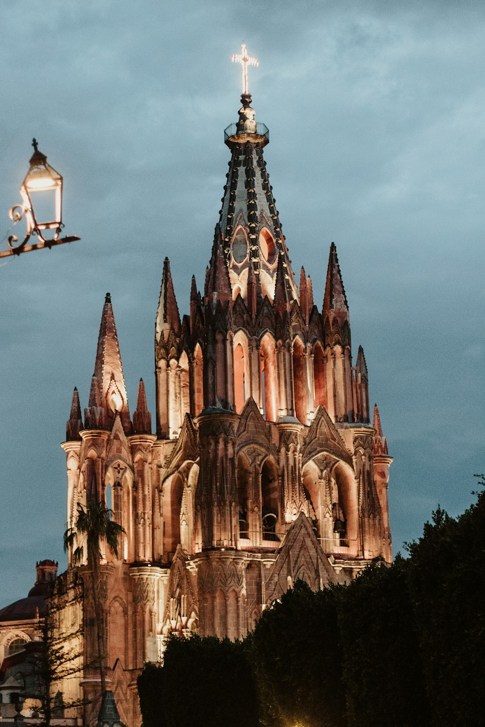 a large cathedral lit up at night under a cloudy sky