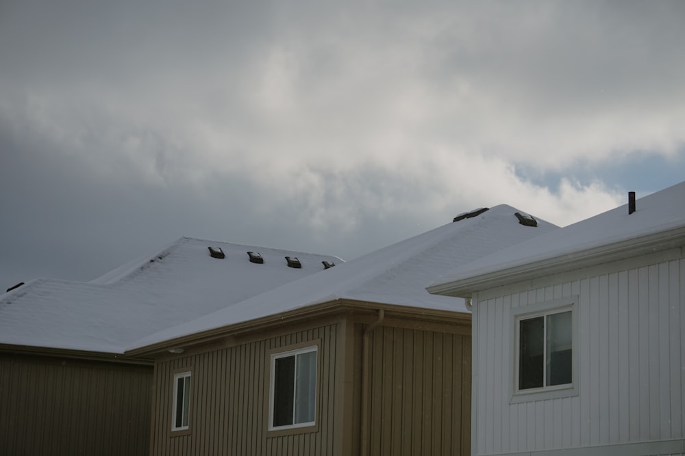 a couple of houses covered in snow under a cloudy sky
