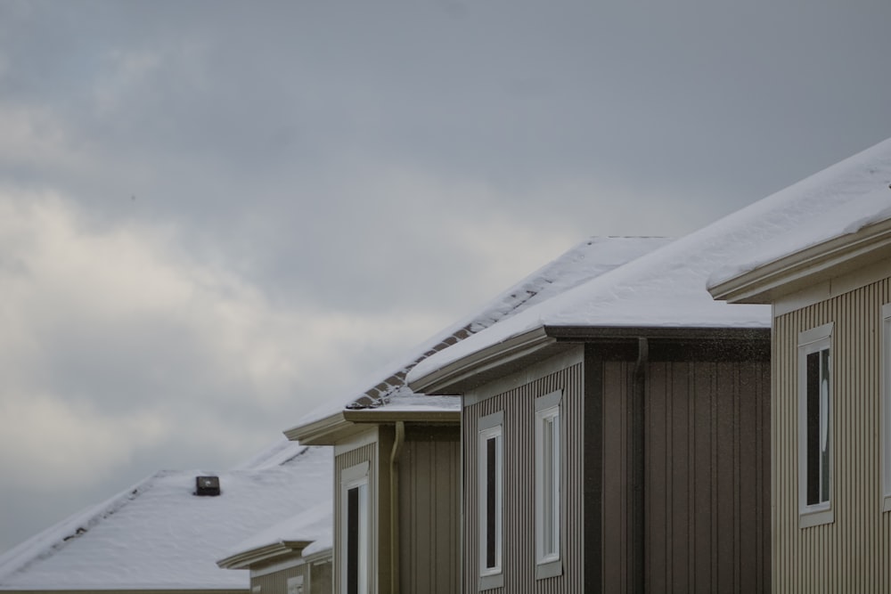 a row of houses covered in snow on a cloudy day