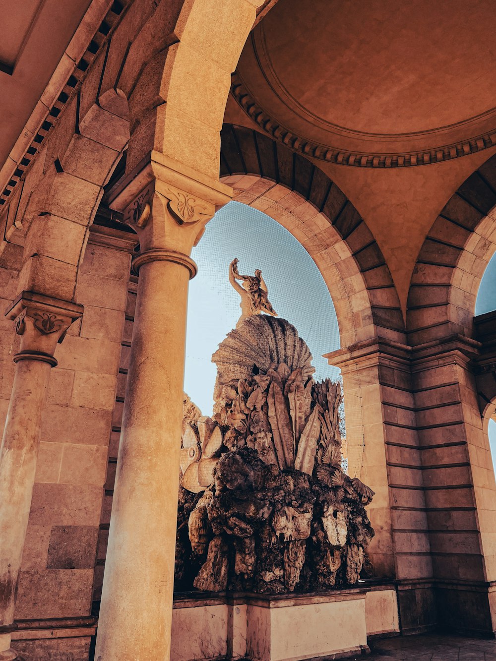 a statue in the middle of a building with arches