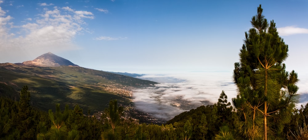 a view of a mountain with clouds below