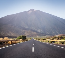 an empty road with a mountain in the background