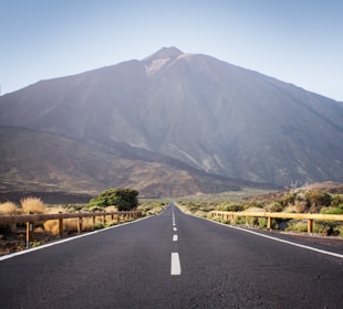 an empty road with a mountain in the background