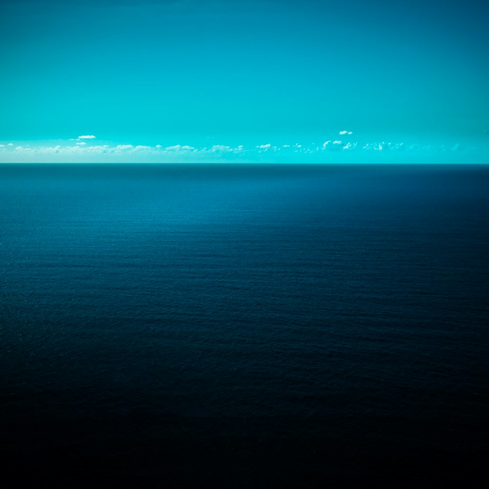 a large body of water sitting under a blue sky