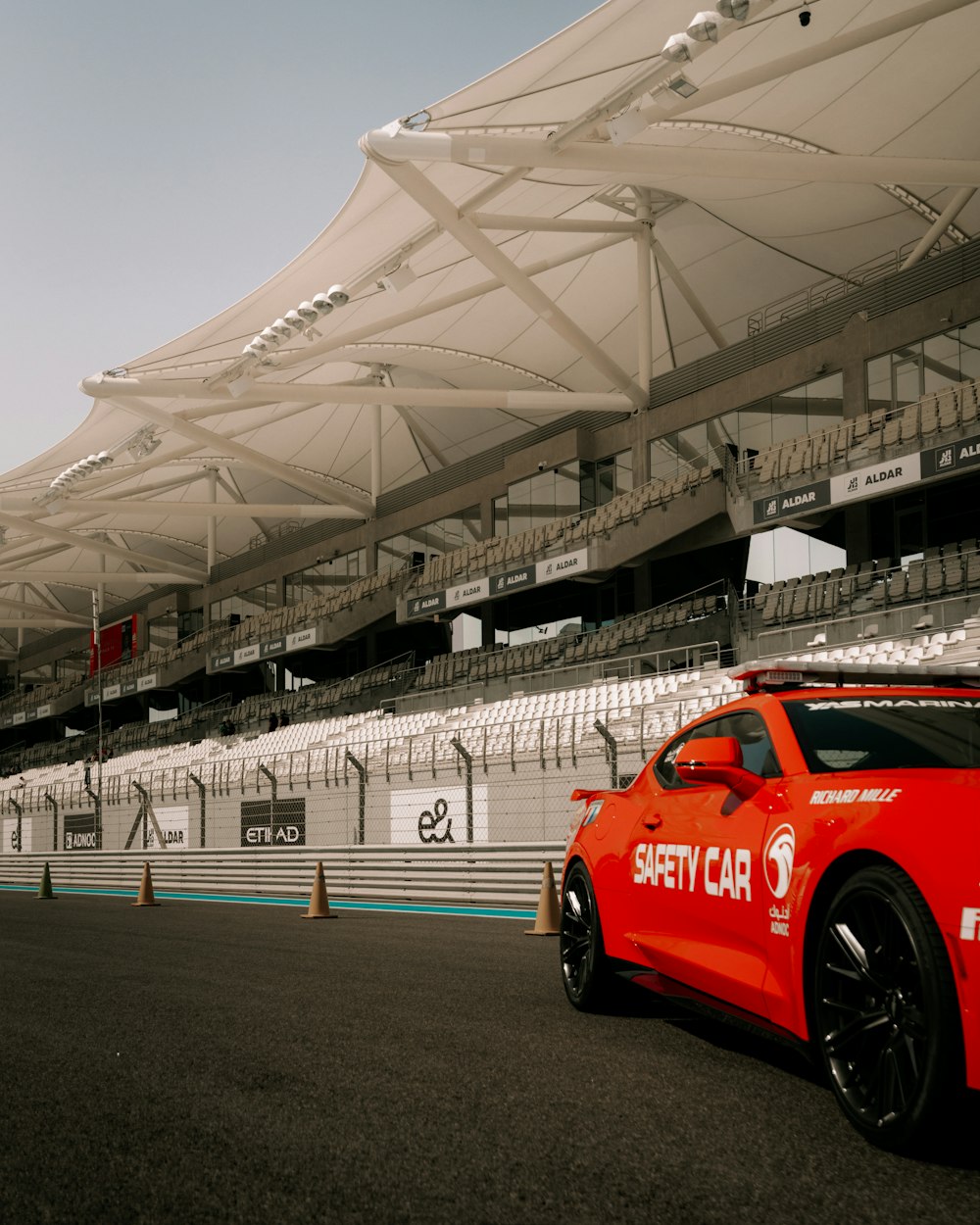 a red sports car is parked in front of a stadium