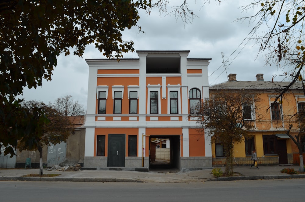 an orange and white building sitting on the side of a road