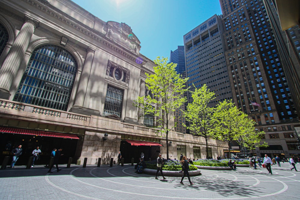 a group of people walking around a large building