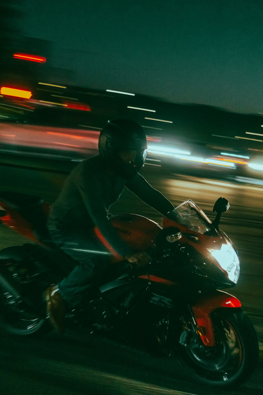 a man riding on the back of a red motorcycle