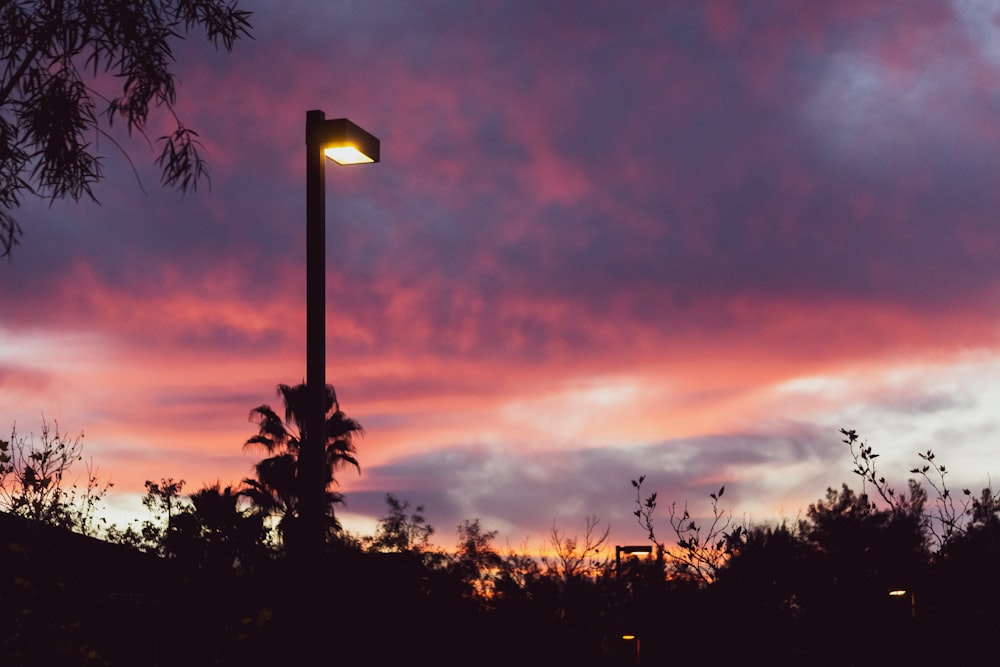 a street light in front of a purple sky