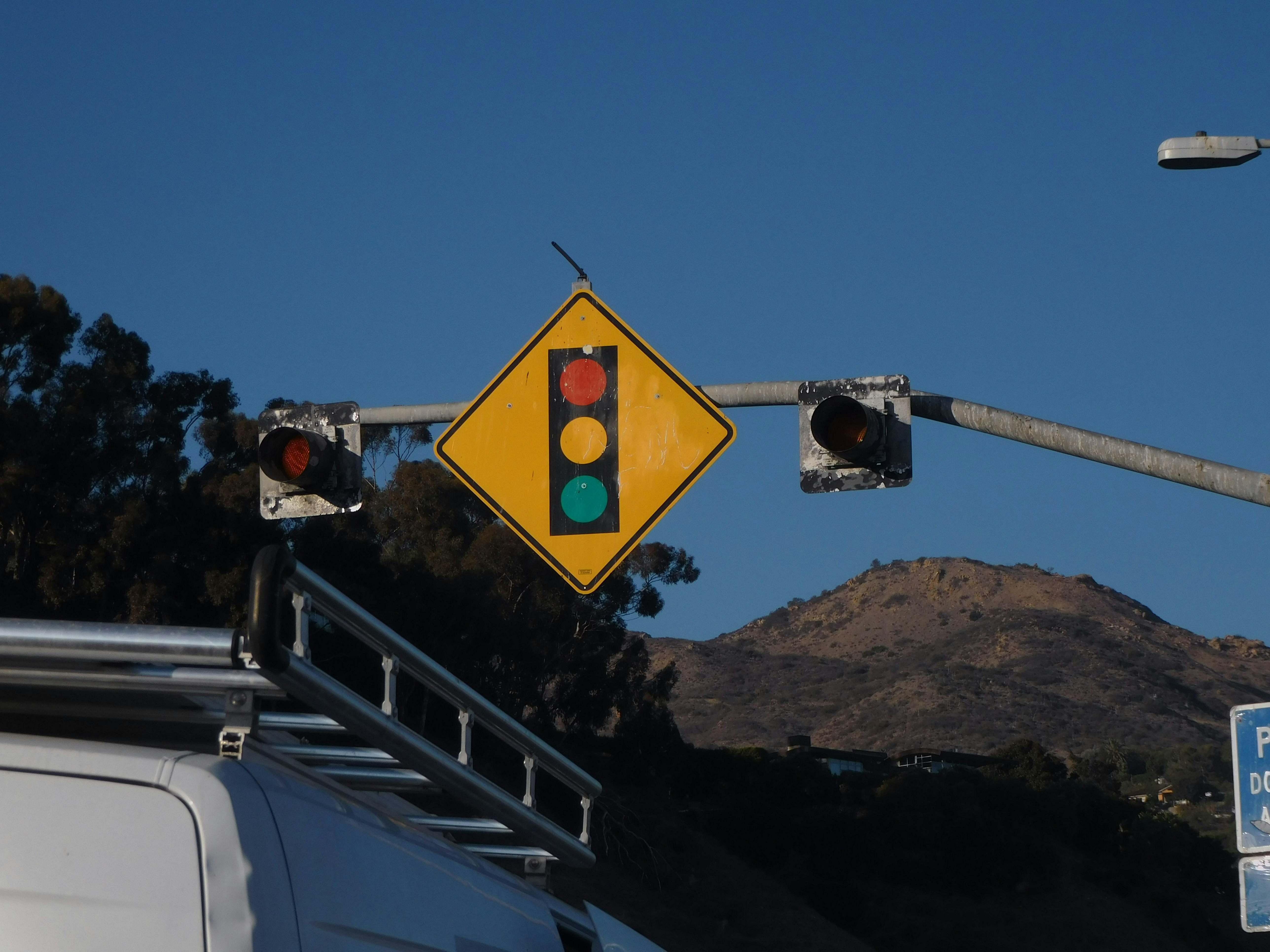 a traffic light hanging over a street next to a van