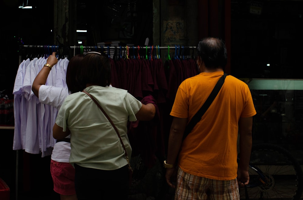 a man and a woman standing in front of a clothing store