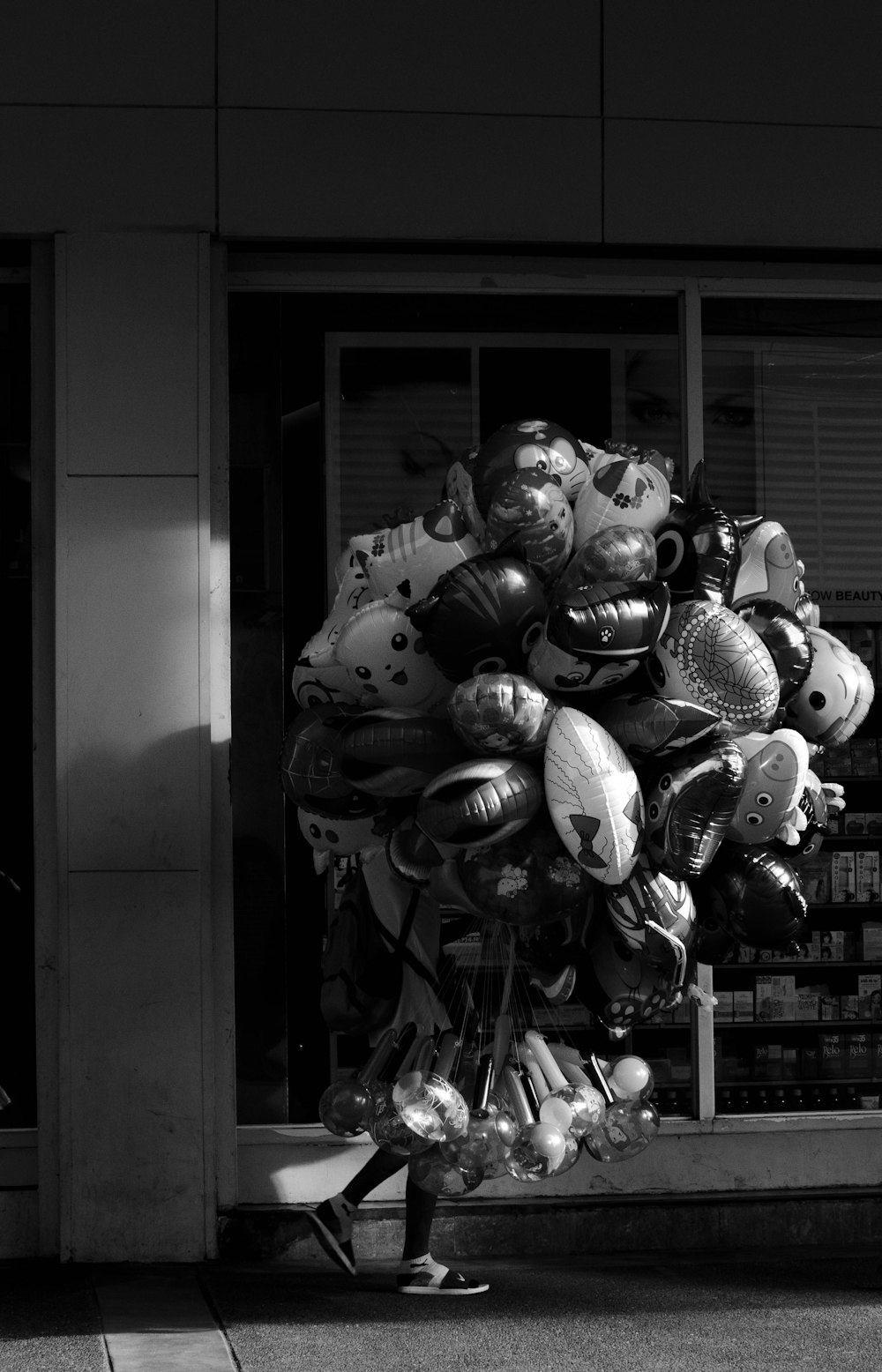 a person walking past a bunch of balloons