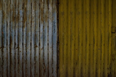 Side-by-side photos showing a metal gate before and after aerogommage treatment.