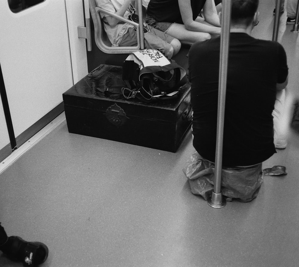 a black and white photo of people sitting on a train