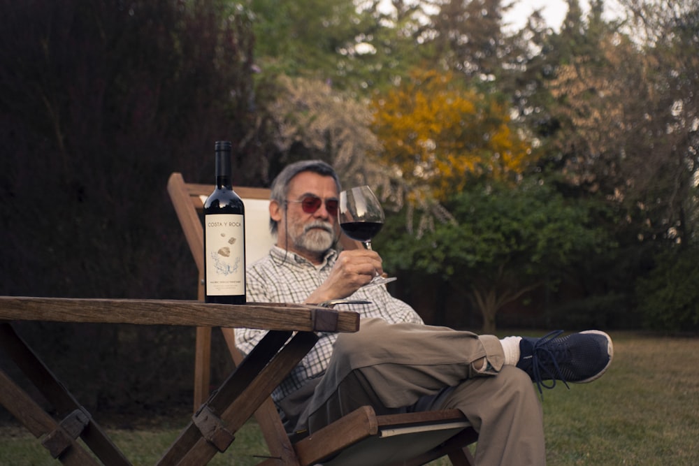 a man sitting in a chair holding a glass of wine