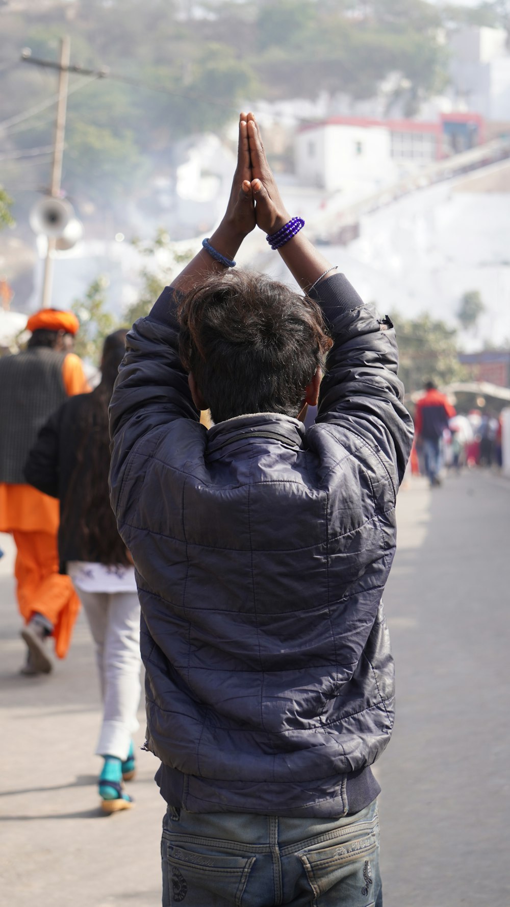 a man standing on a street holding his hands up