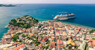Scenic view of a cruise ship approaching the colorful houses of a coastal European town.
