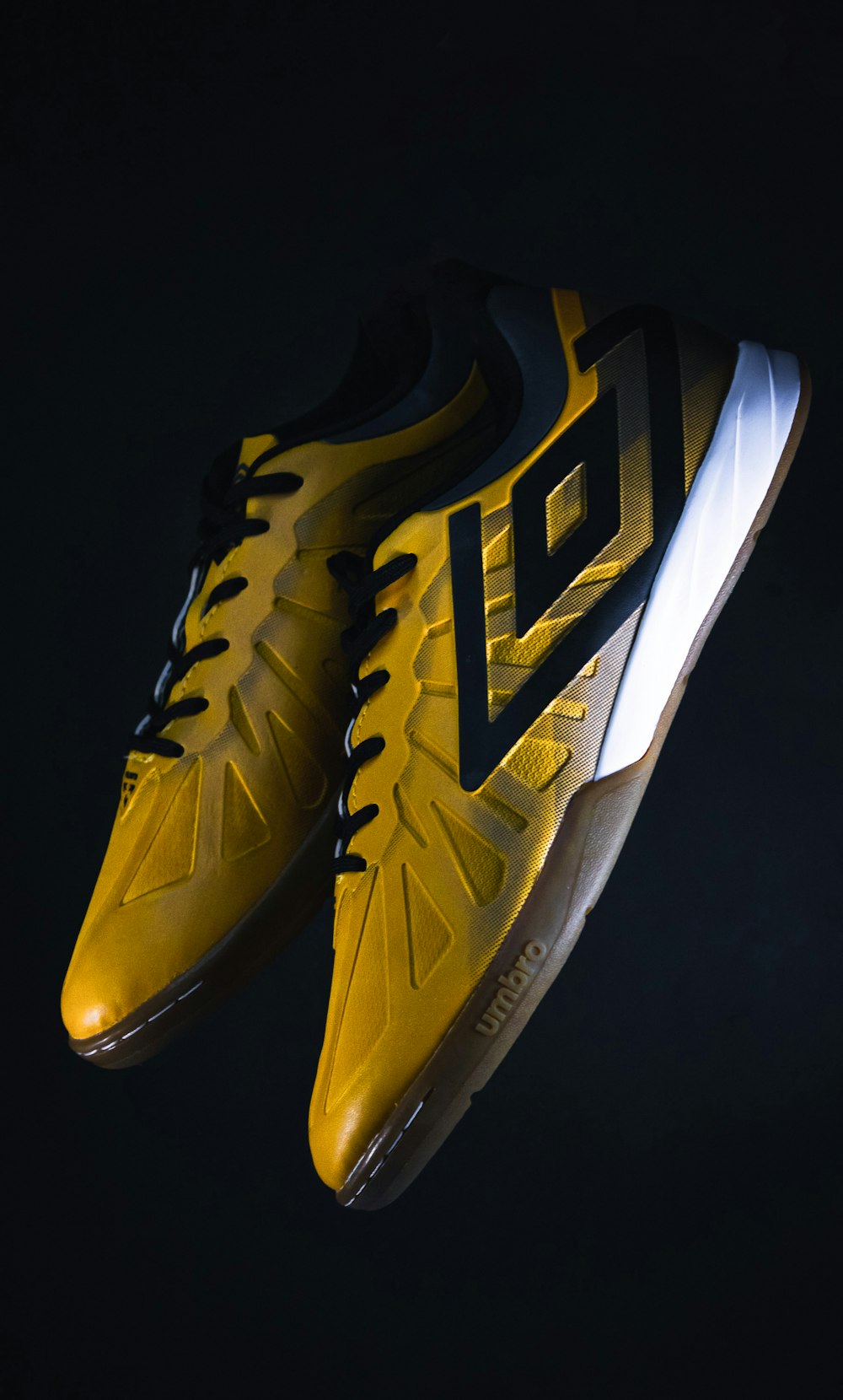 a pair of yellow and black tennis shoes