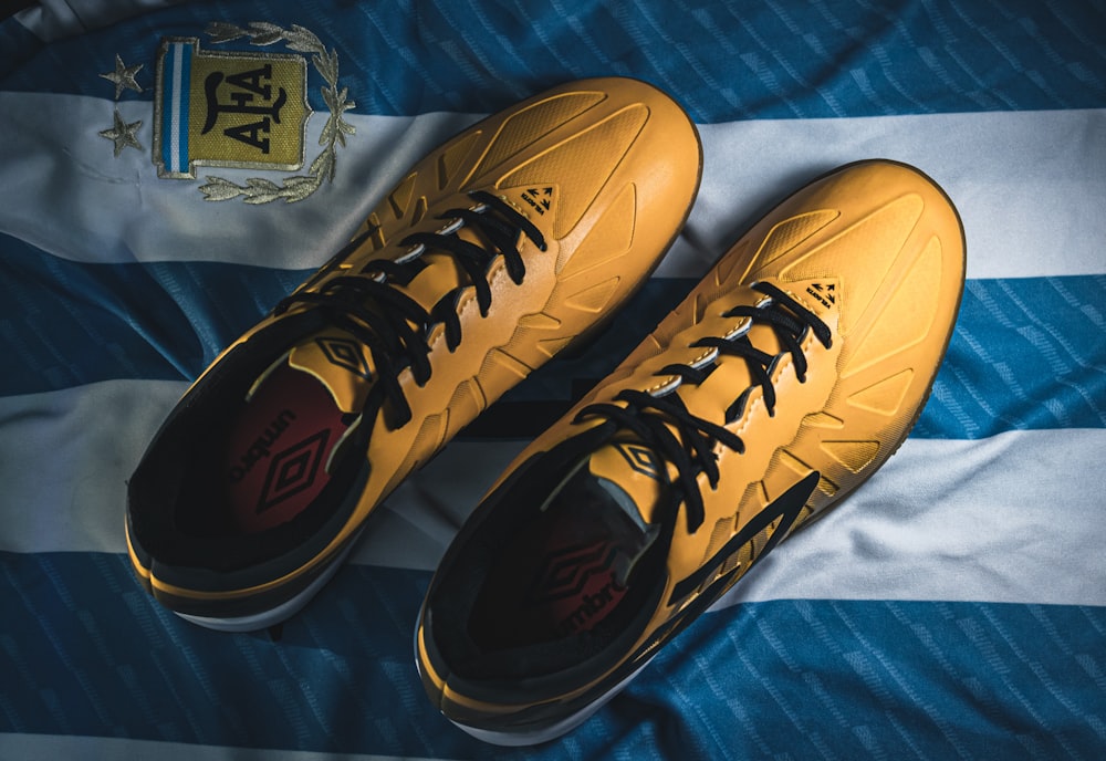 a pair of yellow shoes sitting on top of a bed