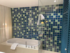 Spacious bathroom with a soaking tub and intricate tile work blending modern and traditional styles.