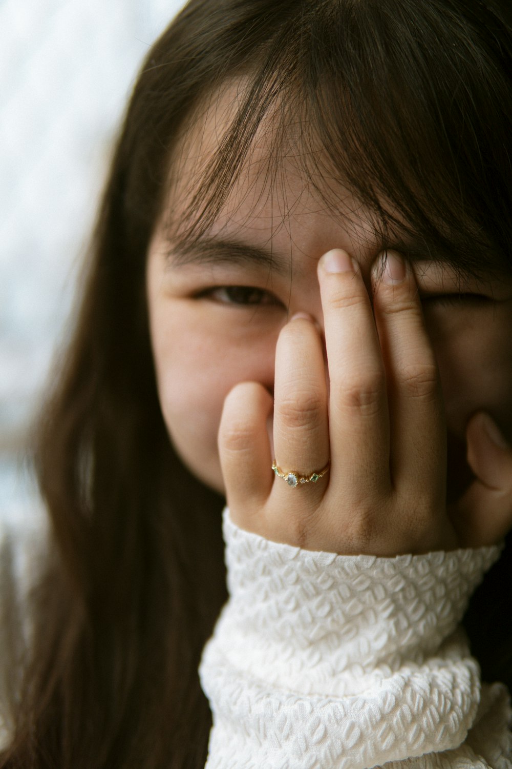 a woman covering her face with her hand