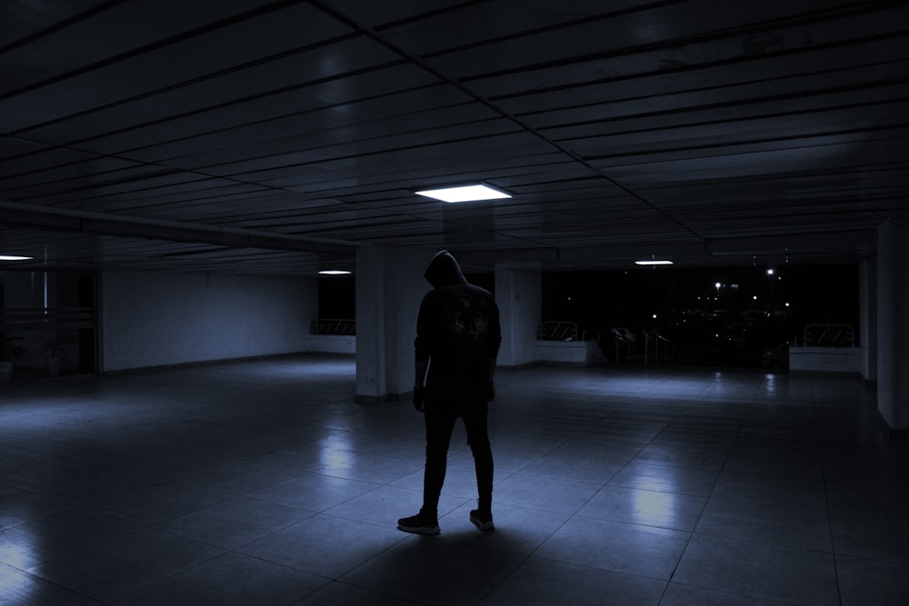 a person standing alone in a dark room