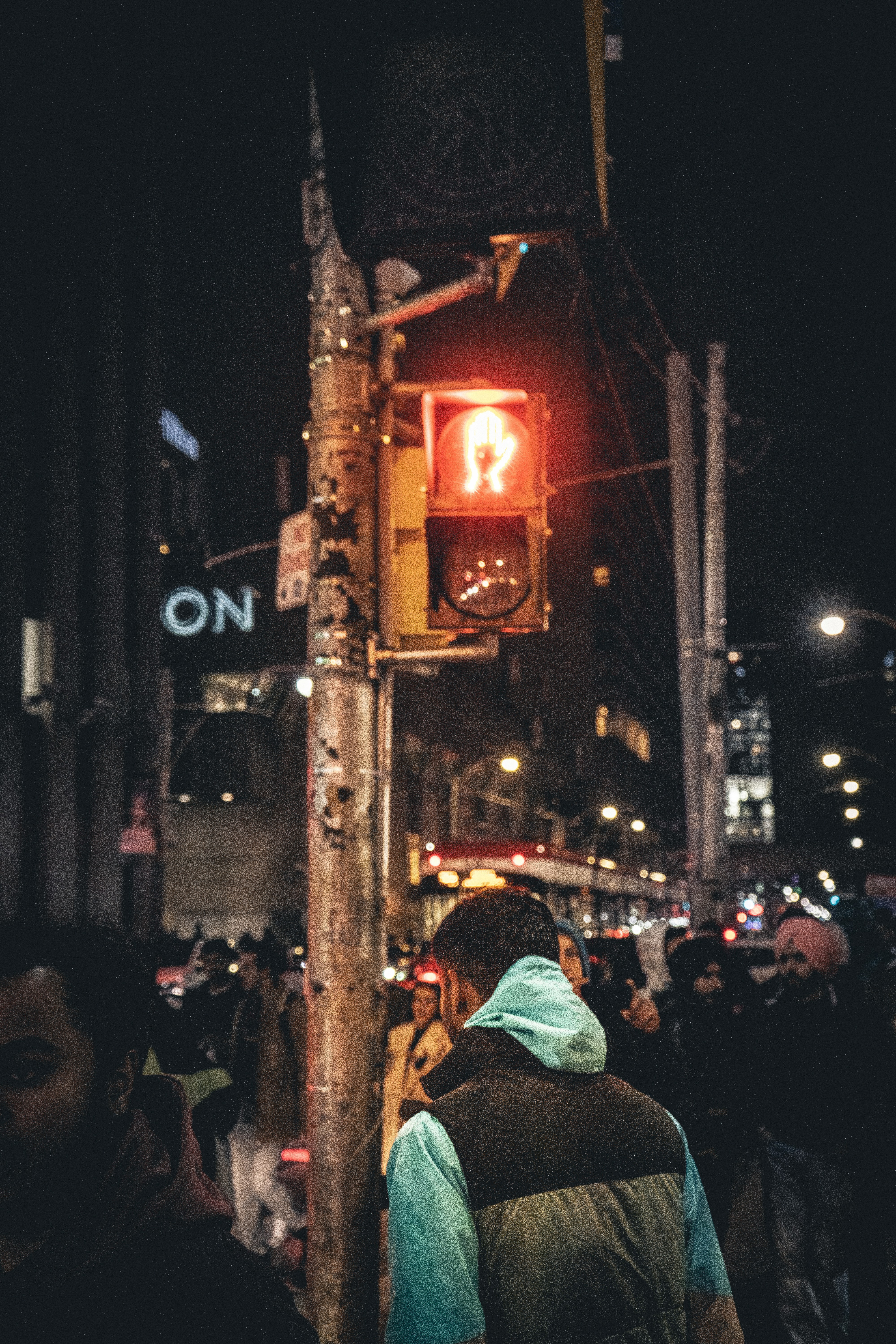 a crowd of people standing on a street next to a traffic light