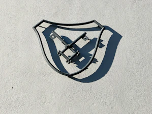 A shield emblazoned with a cross shining against dark charcoal and gold background.