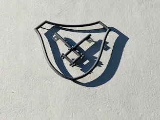 A strong shield with a cross emblem, illuminated by a warm light breaking through shadows.
