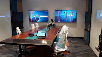 A sleek conference room with a designer sketching event layouts on a tablet.