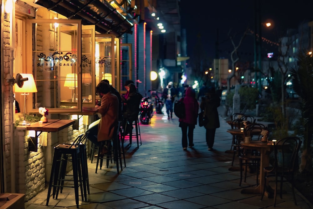 a group of people walking down a street at night