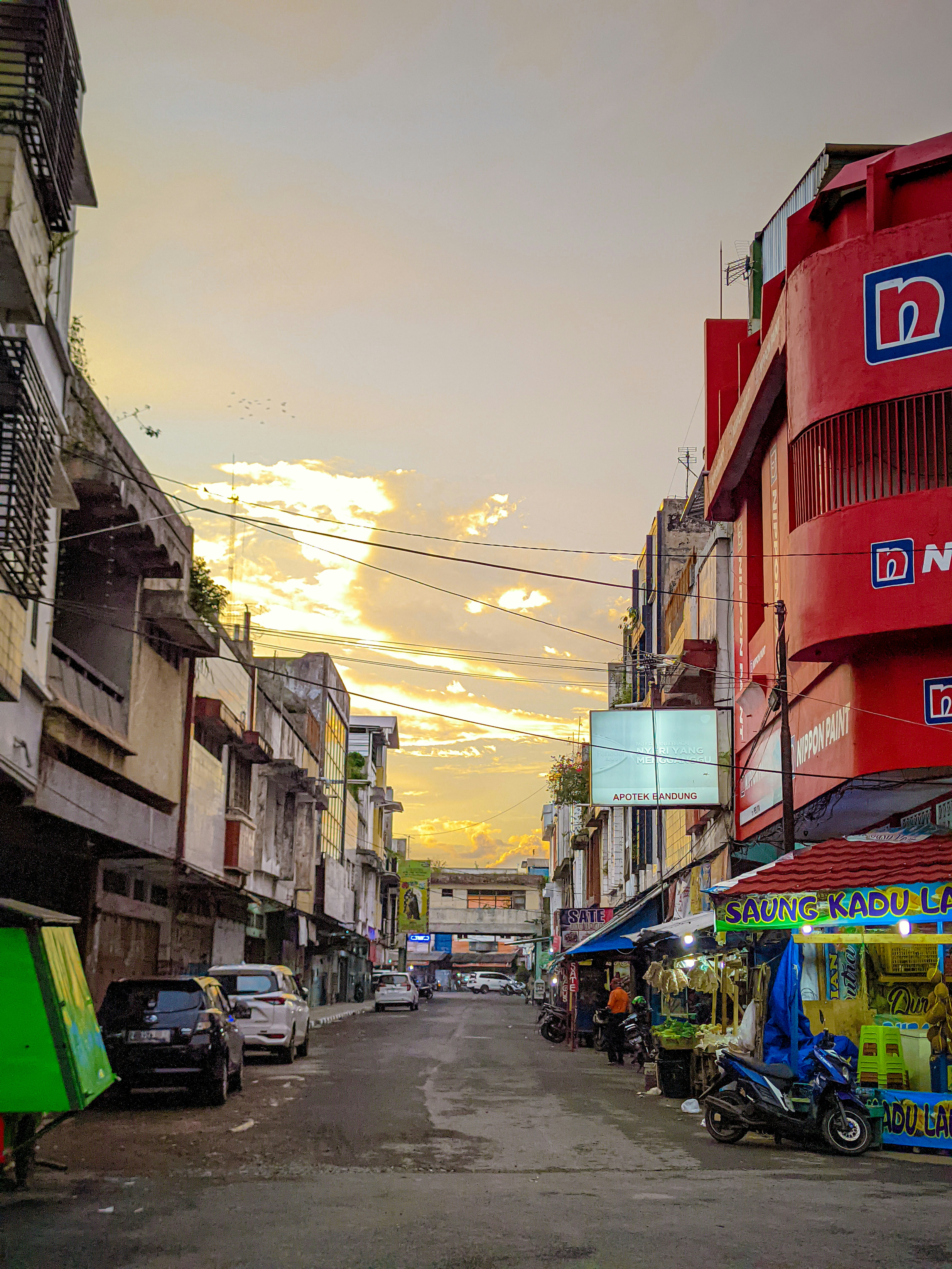 Una calle de la ciudad con coches aparcados a un lado de ella