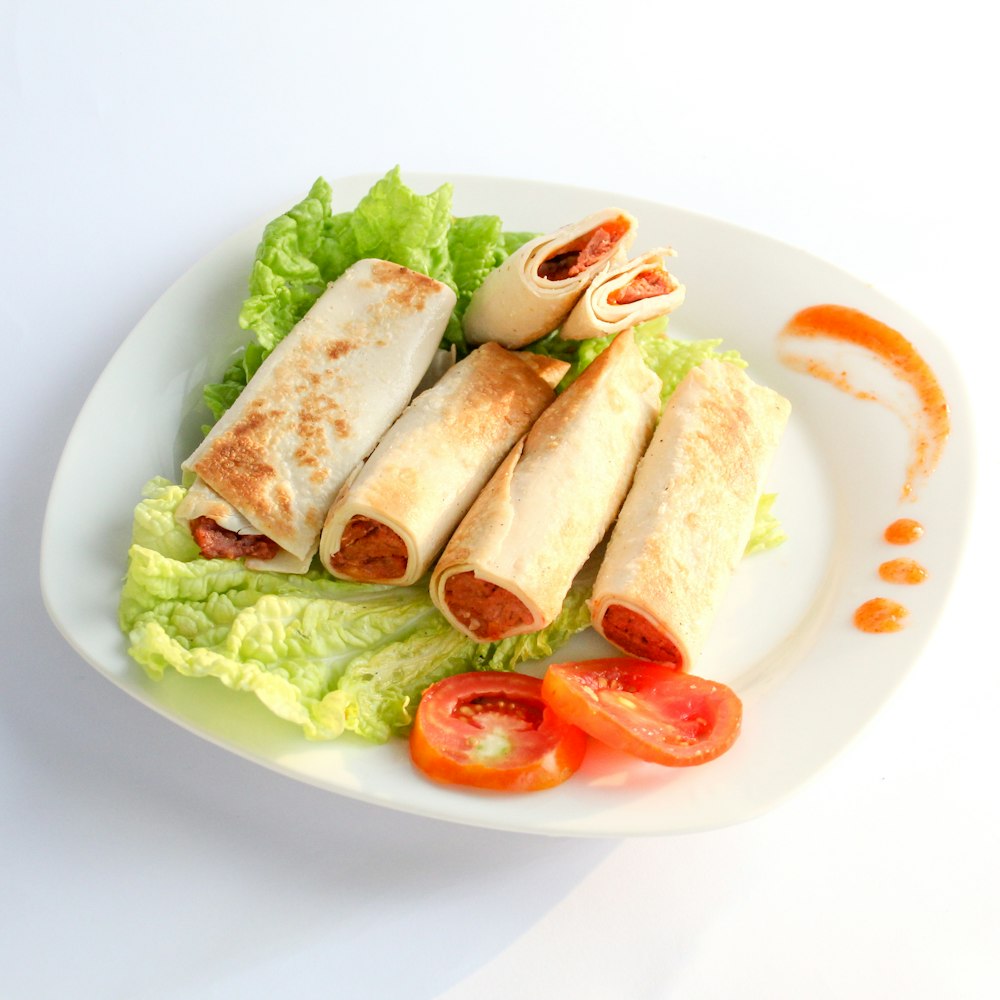 a white plate topped with a salad and a cut in half sandwich