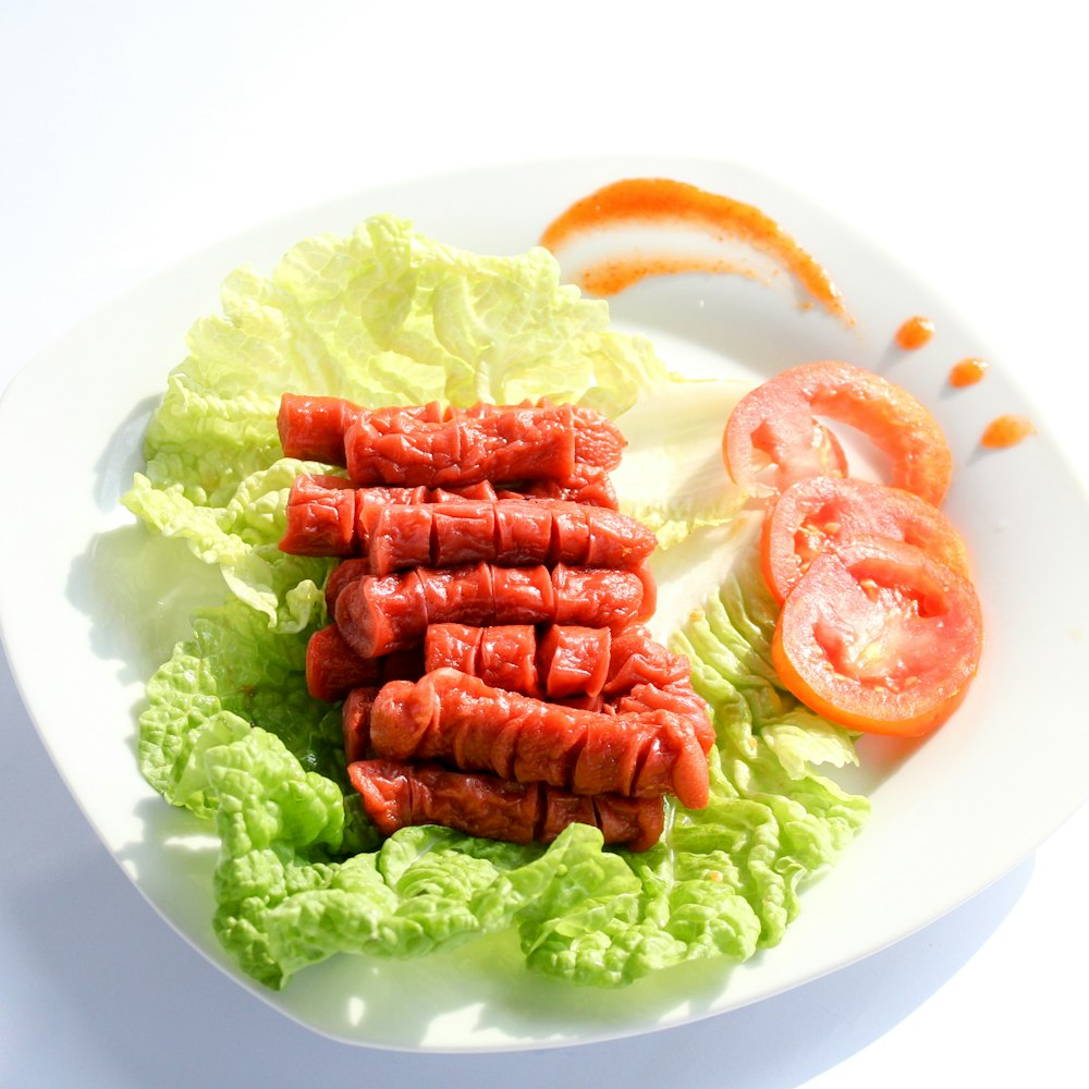 a white plate topped with lettuce and tomatoes