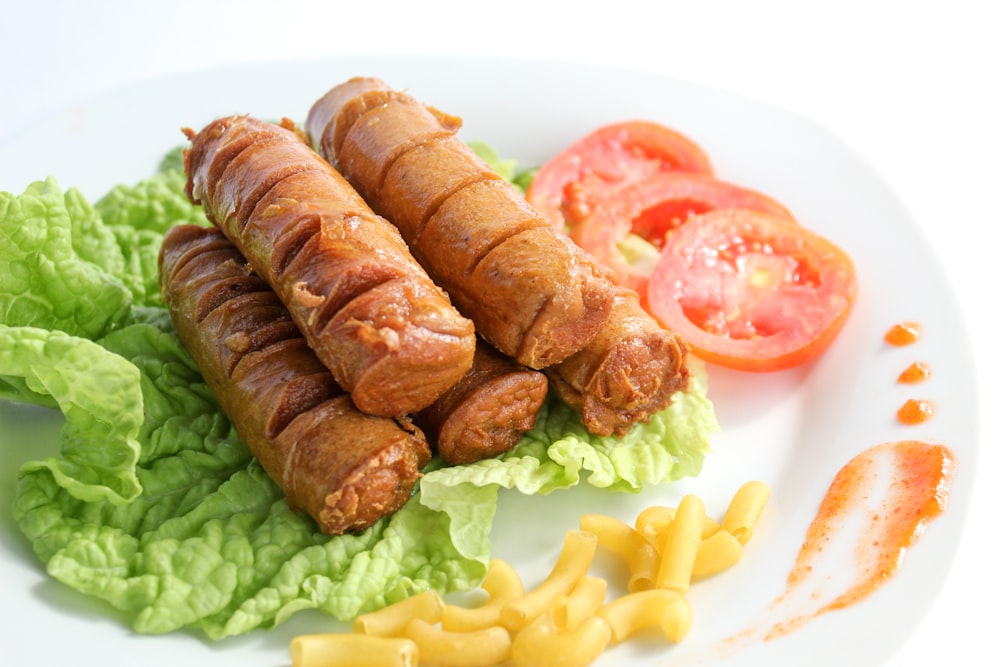 a white plate topped with sausages and lettuce