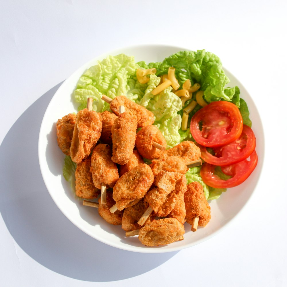a white plate topped with chicken and lettuce