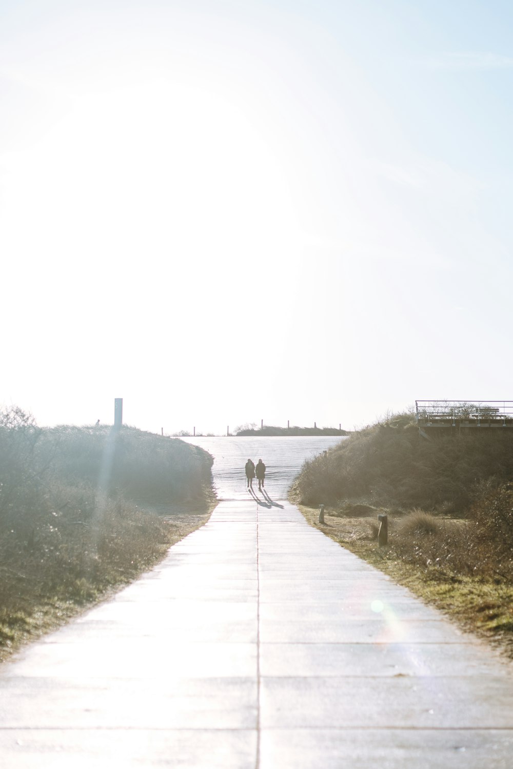 a couple of people walking down a sidewalk