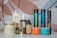 A collection of various hair care and beauty product bottles and jars arranged on a white surface with a colorful, abstract background. The products include bottles with pumps, spray cans, and jars with labels indicating different brands and types. The assortment features products with different colors, shapes, and sizes, suggesting a diverse range of haircare or cosmetic items.