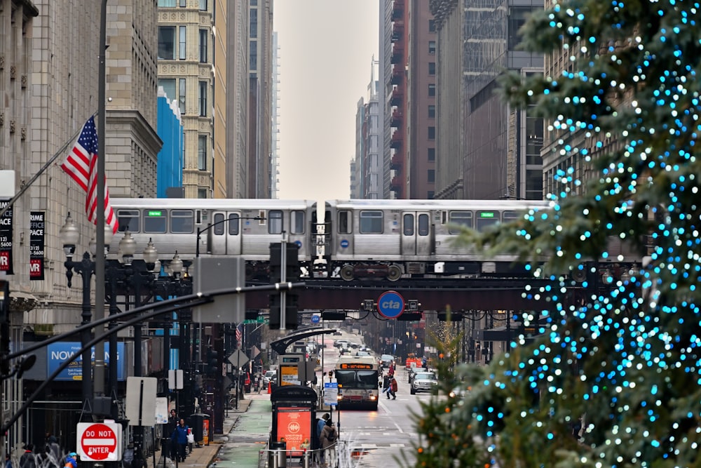 a city street with a christmas tree and a train on the tracks